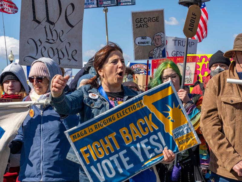 A protestor holds a sign urging a Yes vote on Virginia's redistricting resolution